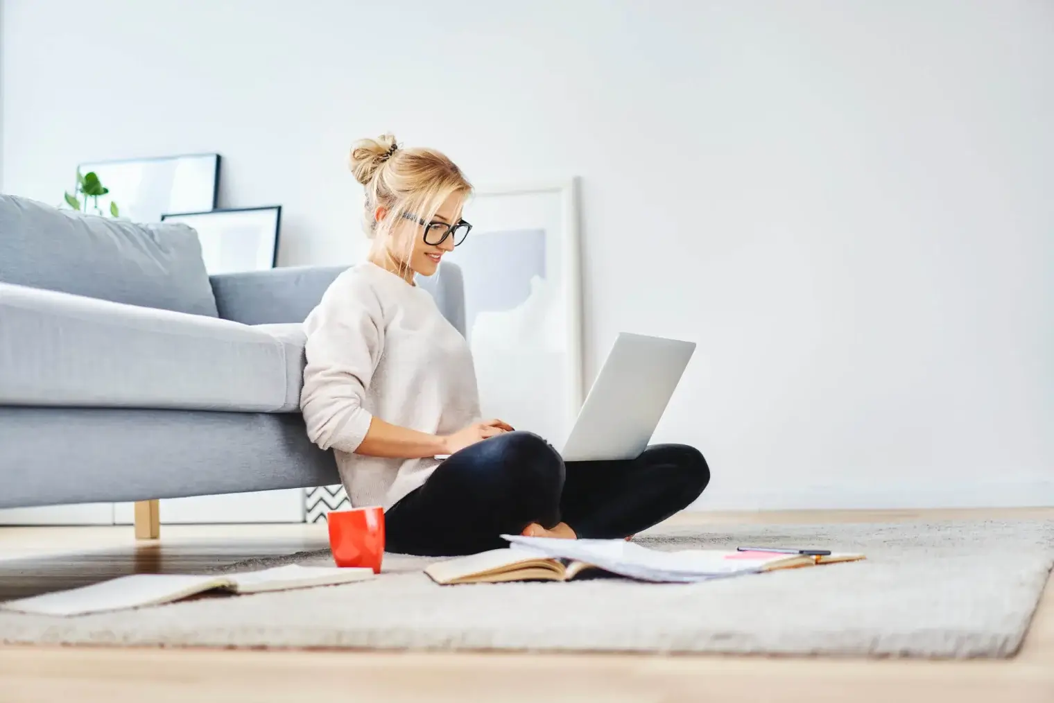 Woman sitting on floor focusing on laptop